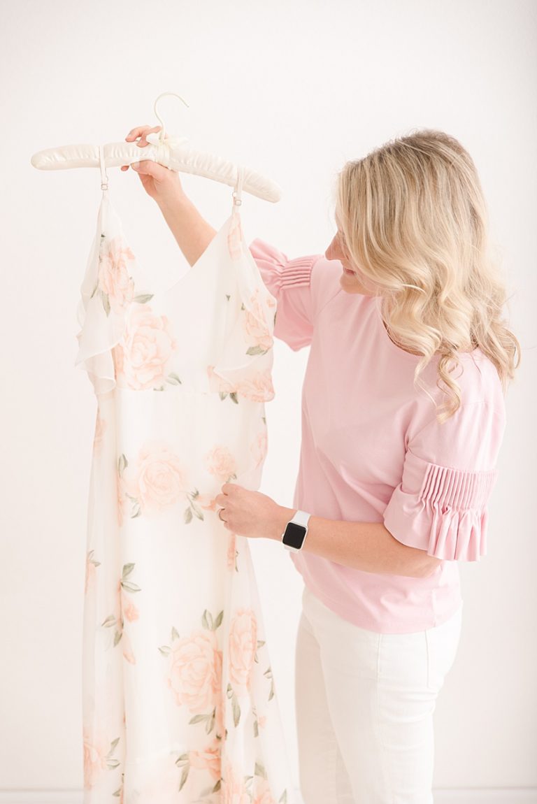 branding photos with photographer holding up maxi dress from client closet
