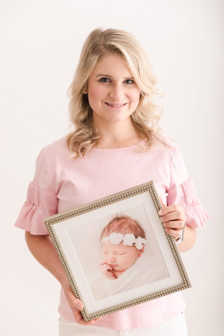 Studio Headshot of Meghan Goering Holding a Custom Framed Newborn Print