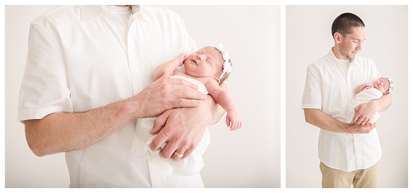 Father holding newborn baby girl by meghan goering photography