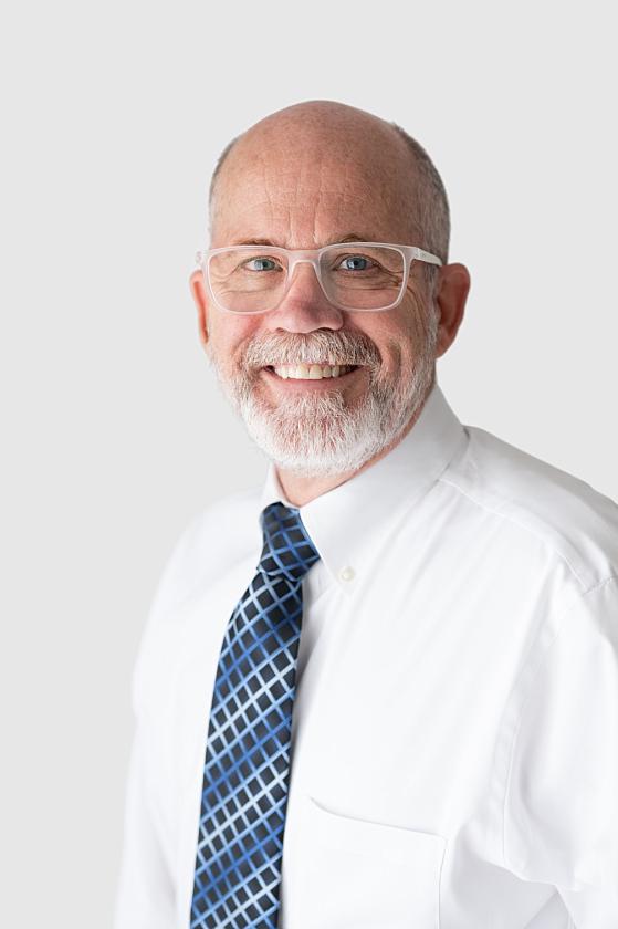 professional business headshot of vanderloo chiropractic doctor with clear glasses and white button down shirt